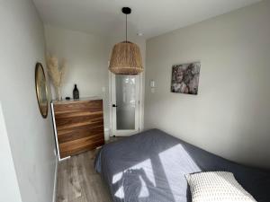 a bedroom with a bed and a dresser and a lamp at Le Riverain - Condo neuf au bord de l'eau in Shawinigan