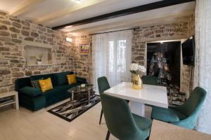 ein Wohnzimmer mit einer grünen Couch und einem Tisch in der Unterkunft Apartment Stone in Split