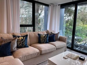 uma sala de estar com um sofá castanho com almofadas azuis em Aurora Ashley Cross em Poole