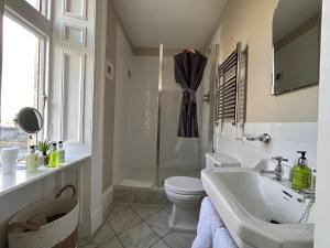 a white bathroom with a toilet and a sink at Hazel Manor in Harrogate