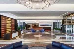 a lobby with blue chairs and a table in a building at Privacy and Exclusivity Condo at Crystal City With Gym in Arlington