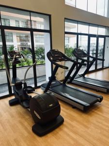 a gym with treadmills and ellipticals in a room with windows at The Signature Apartments, Accra Ghana in Accra