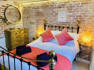 um quarto com uma cama grande com almofadas vermelhas e azuis em Modern Cottage: Free Parking, Garden, Sea Views em St. Agnes