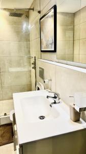 a bathroom with a white sink and a mirror at The Signature Apartments, Accra Ghana in Accra