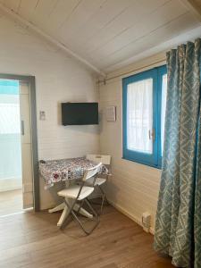 een kamer met een tafel, een stoel en een raam bij Camping Car Palmasera in Cala Gonone