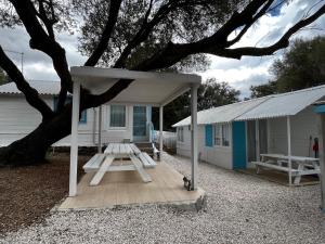 a house with a picnic table in front of it at Camping Car Palmasera in Cala Gonone