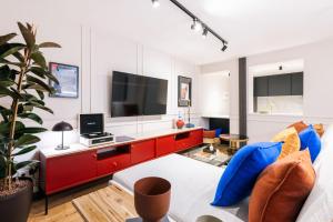 un soggiorno con TV e armadietto rosso di Stylish 4 suites +patio luxury apartment Gran Via a Madrid