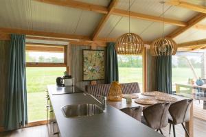 a kitchen with a sink and a table with chairs at Landrijk De Reesprong boerderij in Haaksbergen