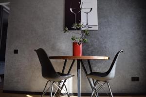 uma mesa com duas cadeiras e um vaso com uma planta em Дизайнерські апартаменти в ЖК DreamTown 10б em Lutsʼk