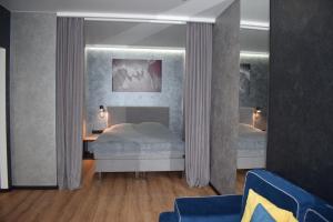 Дизайнерські апартаменти в ЖК DreamTown 10б في لوتسك: غرفة نوم بسرير ومكتب وستائر