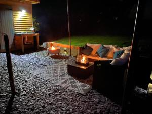 a room with a couch and a table with two candles at Glamping Red Wharf Bay in Pentraeth