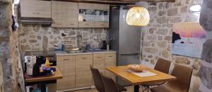 a kitchen with a table and a refrigerator at Gallery House Plouti in Ploutí