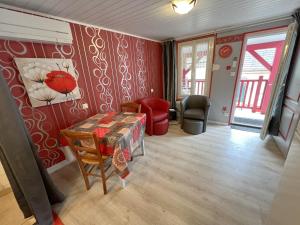 a living room with red walls and a table at Les Meublés du Rocher - Près du parc LE PAL in Bourbon-Lancy
