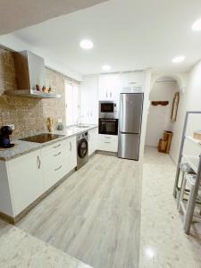 a kitchen with white cabinets and stainless steel appliances at Apartamento La Viñuela in Córdoba