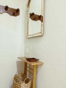 a mirror on a wall next to a small table at Apartamento La Viñuela in Córdoba +40 photos