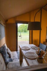 una mesa con platos en una habitación con ventana en Landrijk De Reesprong boerderij en Haaksbergen