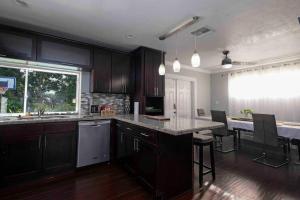 a kitchen with wooden cabinets and a counter top at Cottage in the Gardens! in Miami Gardens
