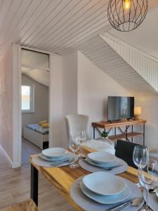 Un comedor con una mesa con platos y copas de vino. en ApartmaniinPrimosten, en Primošten