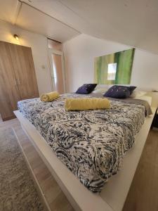 Un dormitorio con una cama grande con dos almohadas encima. en ApartmaniinPrimosten, en Primošten