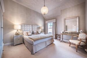 a bedroom with a bed and a desk and a mirror at The Packhorse Inn in Newmarket