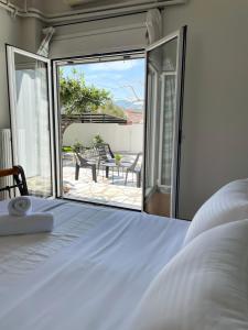 een slaapkamer met een bed en een glazen schuifdeur bij Sunny Beach House in Korinthos