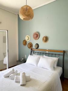 een slaapkamer met een wit bed en 2 handdoeken bij Sunny Beach House in Korinthos