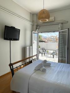 um quarto com uma cama, uma televisão e uma varanda em Sunny Beach House em Corinto