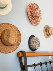 a group of hats hanging on a wall at Sunny Beach House in Korinthos