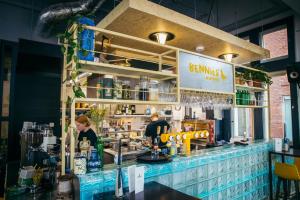 a bar with two people standing behind a counter at Hostel & Bar De Basis in Zwolle