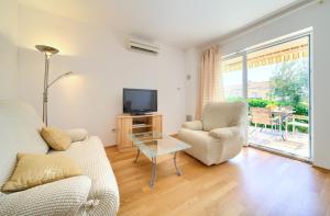 een woonkamer met een bank, stoelen en een tv bij Happy Point in Krk