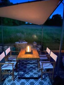 a table and chairs under a tent with a candle at Glamping Red Wharf Bay in Pentraeth