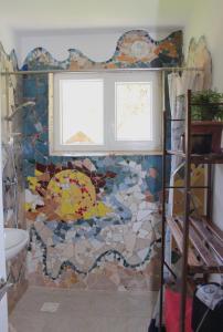 a bathroom with a mosaic wall with a window at Art house Tufi in Bistrica ob Sotli