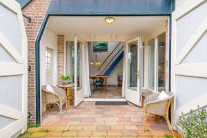 een deur naar een patio met stoelen en een tafel bij Vakantiehuis De Dars - Callantsoog in Callantsoog