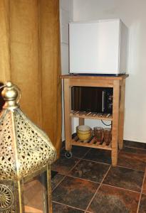 a room with a table with a microwave and a chair at Aladin Comfort Country Rooms in Campinho
