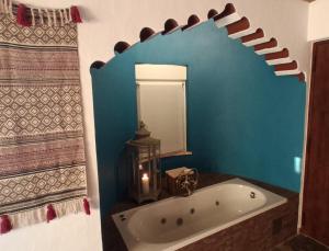 uma casa de banho com uma banheira e um espelho. em Aladin Comfort Country Rooms em Campinho