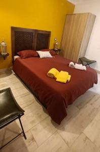a bedroom with a large bed with yellow towels on it at Aladin Comfort Country Rooms in Campinho