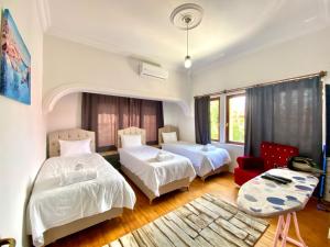 a bedroom with two beds and a red chair at Ali Apart in Antalya