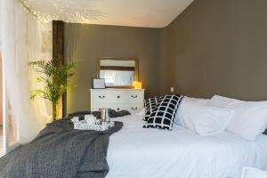 a bedroom with a white bed with a dresser and a mirror at Sweet Surrender in Santander