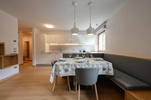 a dining room and kitchen with a table and chairs at Casa al Parco Deluxe in Canazei