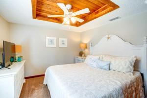 una camera con letto bianco e ventilatore a soffitto di Indian Rocks Beach Cottage, Walk to Beach! a Clearwater Beach