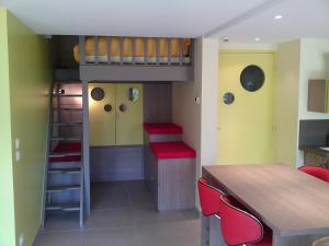 a room with a bunk bed and a table and chairs at Gîte des Pringets in Tresserves