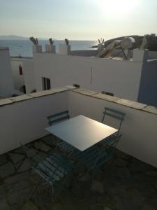 une table blanche et deux chaises sur le toit dans l'établissement Villa Foivos, à Agios Romanos