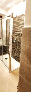 bagno con doccia e parete in vetro di Ristorante Bellavista con Locanda a Veleso