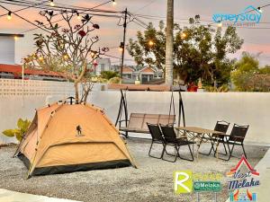 ein Zelt auf dem Boden neben einem Tisch in der Unterkunft Klebang Villa 17Pax PrivateSwimmingPool TownArea By Heystay Management in Malakka