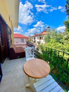 a wooden table and two white chairs on a balcony at Ali Apart in Antalya