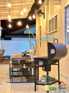 cocina con parrilla, mesa y sillas en Klebang Villa 17Pax PrivateSwimmingPool TownArea By Heystay Management, en Melaka