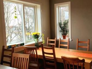 a dining room with a table and chairs and two windows at Igdlo Guesthouse in Reykjav&iacute;k