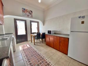 a kitchen with a refrigerator and a table with chairs at Ali Apart in Antalya