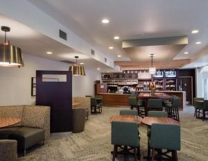 a restaurant with tables and chairs and a bar at Courtyard by Marriott Hickory in Hickory