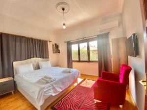 a bedroom with a bed and a red chair at Ali Apart in Antalya